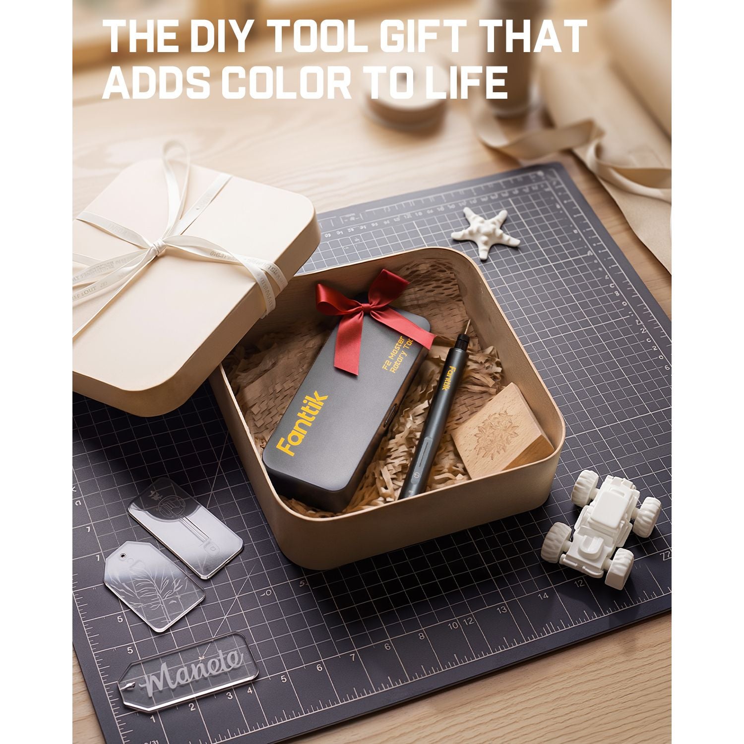 Festive gift set with Fanttik F2 Master Kit Cordless Rotary Tool and decorative elements on a cutting mat.