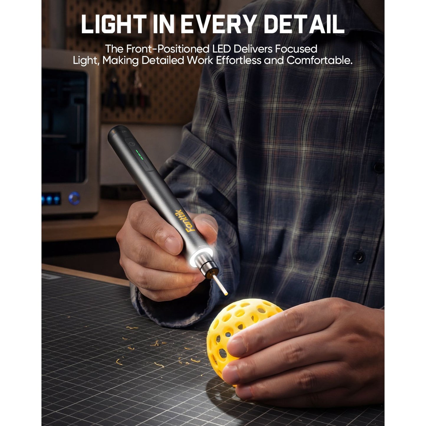 Person using a Fanttik F2 Master Kit Cordless Rotary Tool with a light on a workbench, emphasizing detailed work.