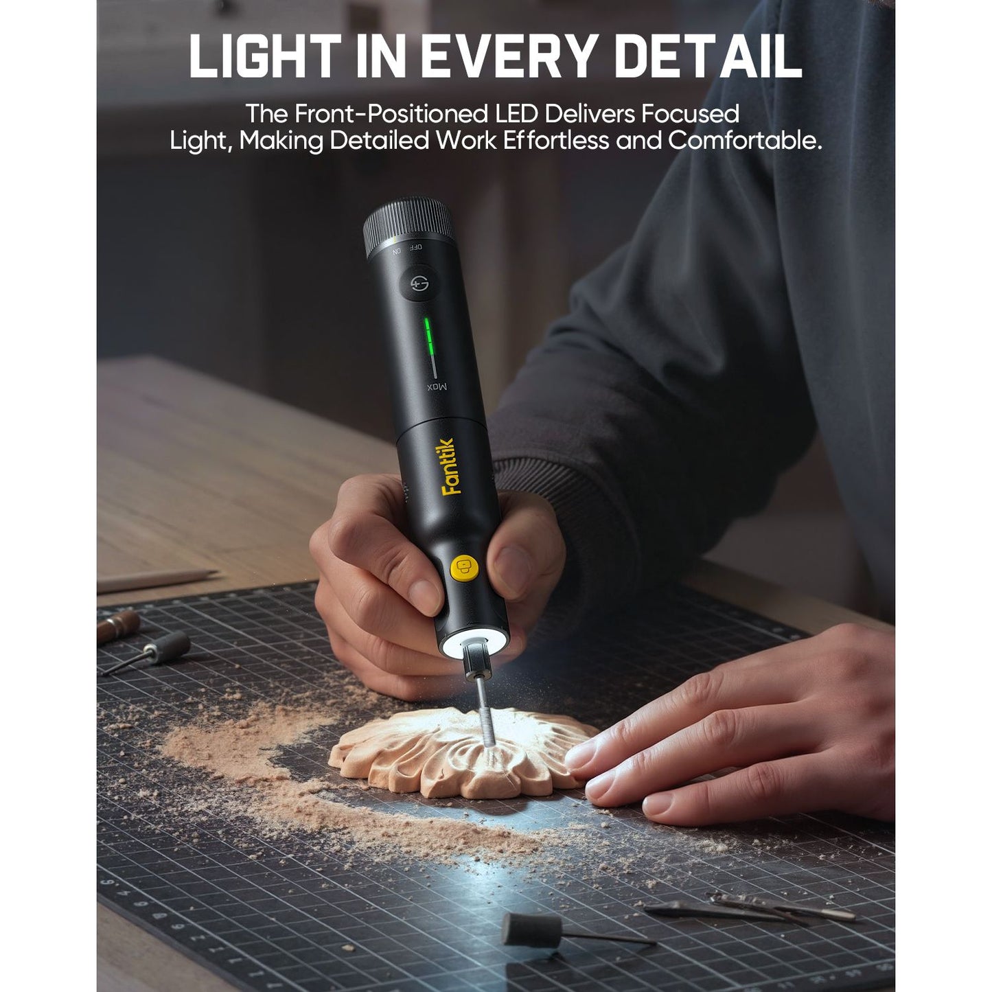 Person using a Fanttik F2 Pro Kit Cordless Rotary Tool with a light on a workbench, highlighting the tool's focused light.