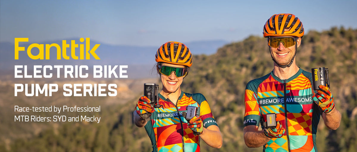 Two cyclists in colorful jerseys and helmets holding electric bike pumps with a scenic background.