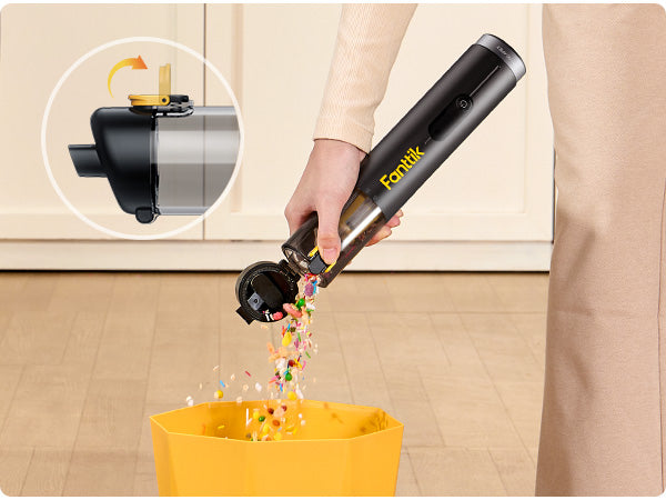 Person using a Fanttik Slim V10 APEX Cordless Car Vacuum to clean up colorful confetti on a wooden floor.